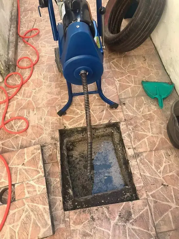 Equipamento de desentupimento em caixa de gordura aberta em piso externo