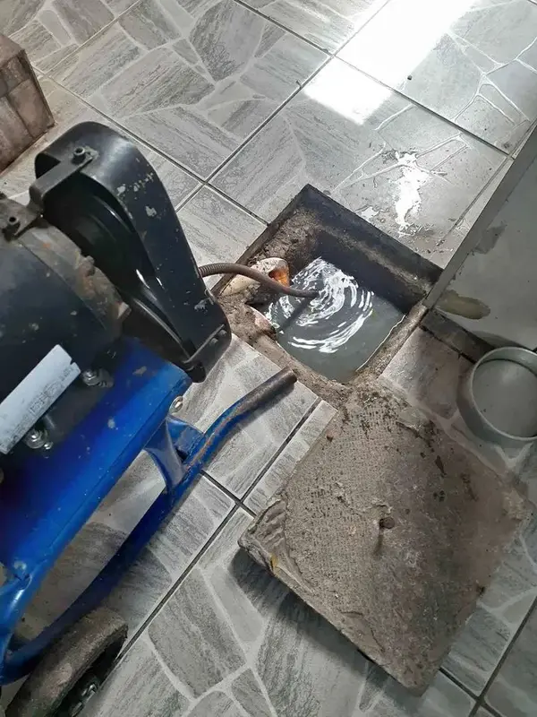 Máquina de desentupimento posicionada em caixa de inspeção de esgoto durante atendimento
